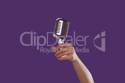 Female hand holding up a microphone