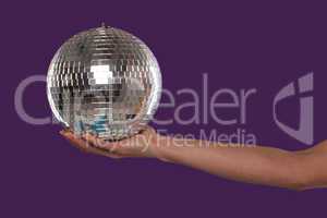 Female hand cupping a silver disco ball