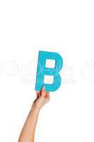 hand holding up the letter B from the bottom