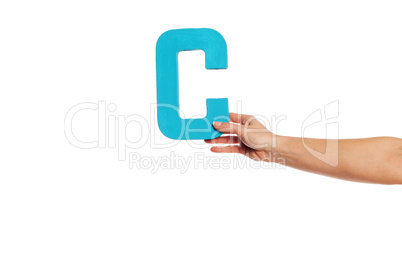 hand holding up the letter C from the right