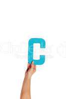 hand holding up the letter C from the bottom