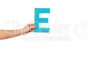 hand holding up the letter E from the left