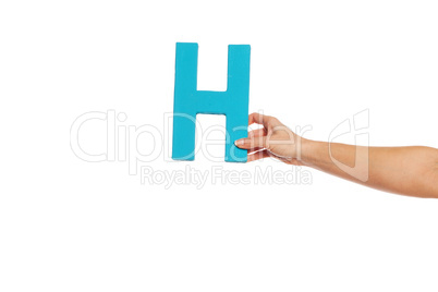 hand holding up the letter H from the right