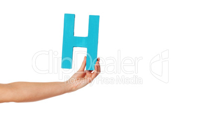 hand holding up the letter H from the left