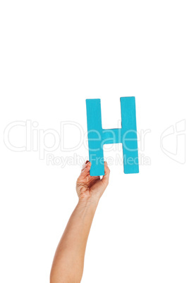 hand holding up the letter H from the bottom