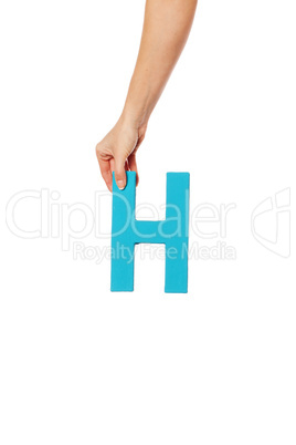 hand holding up the letter H from the top