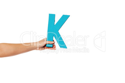 hand holding up the letter K from the left