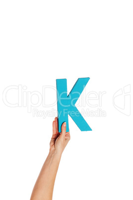 hand holding up the letter K from the bottom