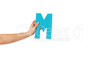 hand holding up the letter M from the left