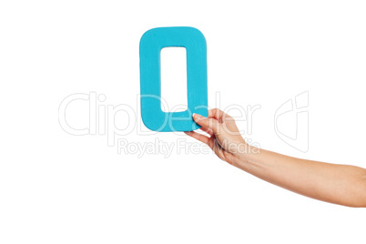 hand holding up the letter O from the right