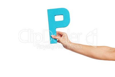 hand holding up the letter P from the right