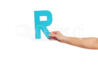 hand holding up the letter R from the right