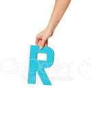 hand holding up the letter R from the top