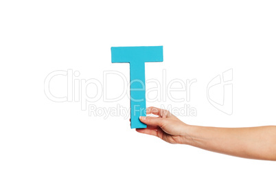 hand holding up the letter T from the right