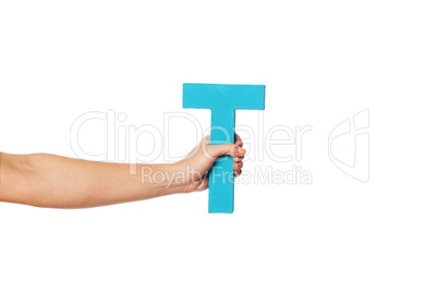 hand holding up the letter T from the left