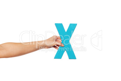 hand holding up the letter X from the left