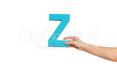 hand holding up the letter Z from the right