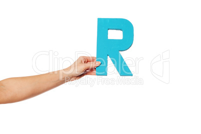 hand holding up the letter R from the left