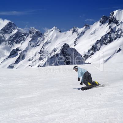 Snowboarder on ski piste in high mountains
