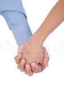 Closeup of young affectionate couple holding hands over white ba