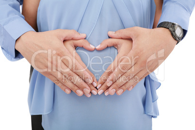 hands of pregnant woman and her husband in heart shape