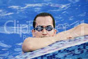 Male Swimmer resting after several laps in the indoor swimming p