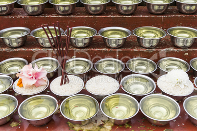 small bowls with water and rice around a temple