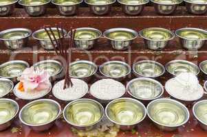 small bowls with water and rice around a temple