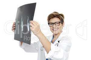 Experienced female doctor examining x-ray report