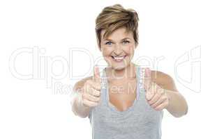 Excited middle aged lady showing double thumbs up