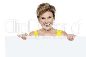Attractive woman holding blank whiteboard