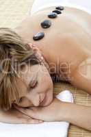 Pretty woman enjoying hot stone therapy