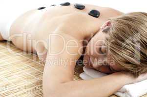 Woman getting a spa treatment with stone massage