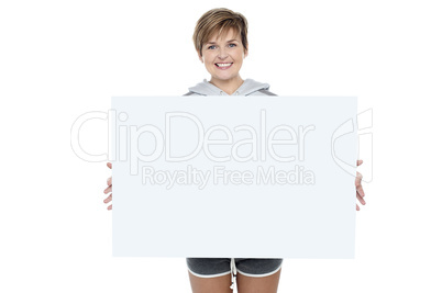 Charming young woman holding white ad board