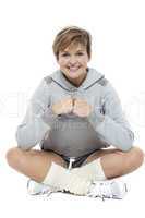 Adorable woman in sports wear sitting on the floor