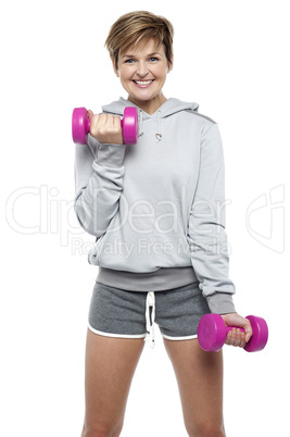 Sporty middle aged woman with dumbbells