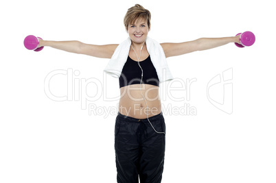 Lady enjoying music and exercising with dumbbells