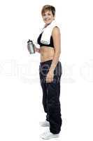 Fitness woman posing after workout. Holding water bottle