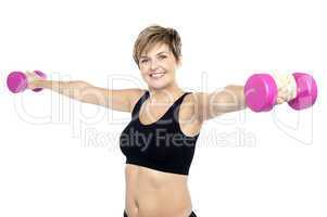 Fitness woman working out with pink dumbbells