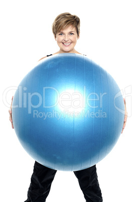 Charming woman holding big blue fitness ball