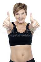 Excited attractive fit lady showing double thumbs up