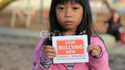 Sad Asian Girl Holds A Stop Bullying Sign