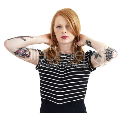 Red Head Holding Hair in Pigtails with Arms Covered in Tattoos