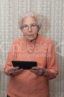 Eine alte Frau mit dem Tablet Computer