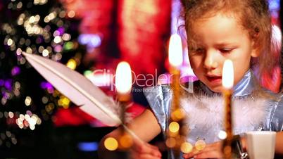 Girl writing with quill pen. Xmas concept