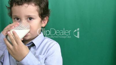 Little boy drinking milk on green screeen