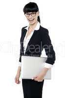 Cheerful office employee holding laptop