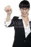 Smiling young business lady holding up a key