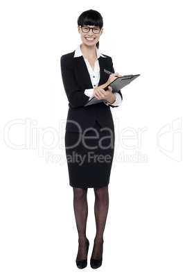 Female secretary jotting down notes on writing pad