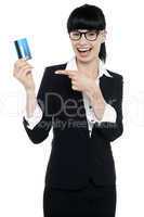 Businesswoman in glasses pointing at credit card